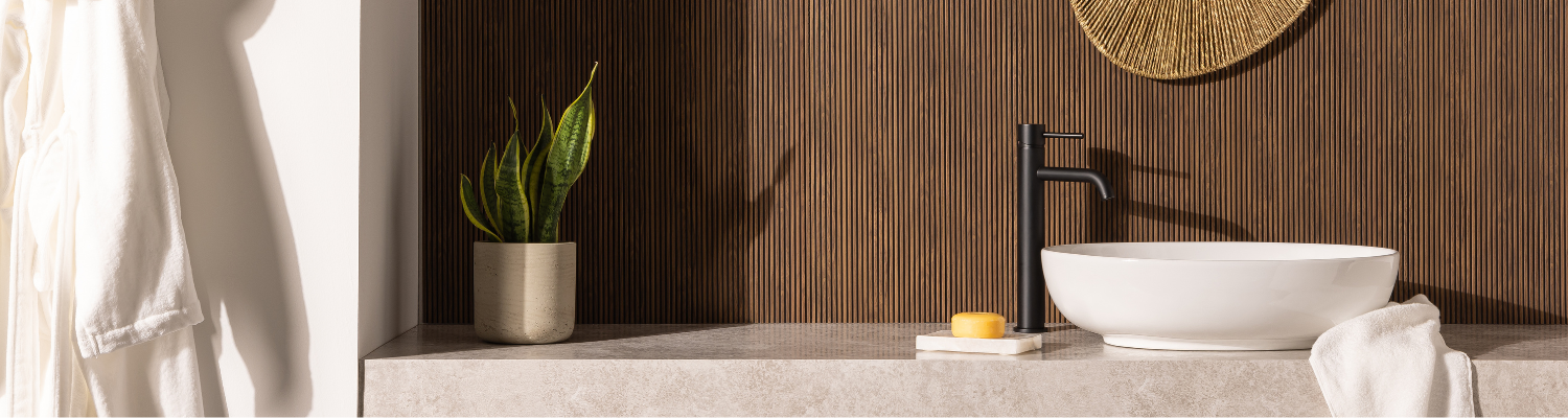 Bathroom vanity with snake plant, sink and soap. MicroSlat Deep Walnut on the wall.